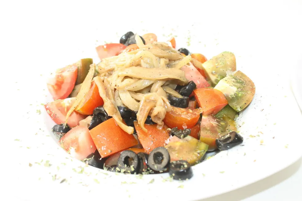 Ensalada de tomate con aceitunas negras servida en A’rocha