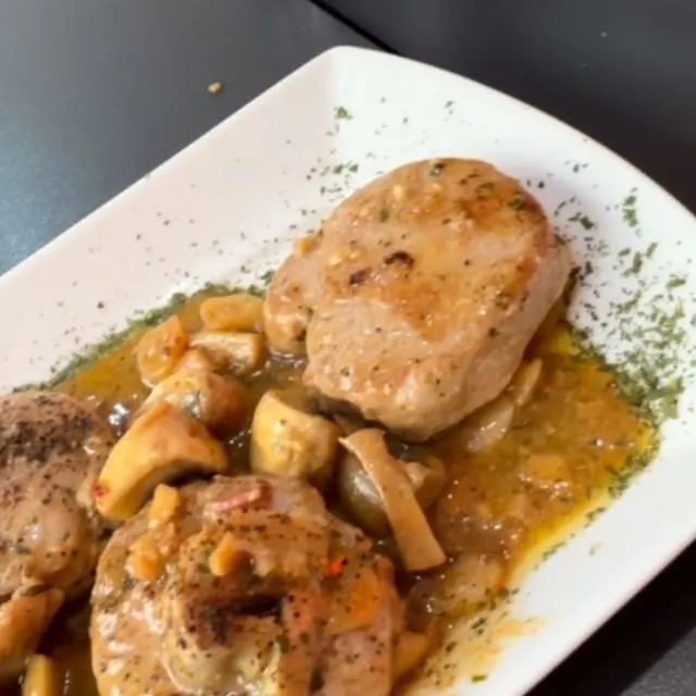 Medallones de solomillo con champiñones y almendras en reducción de Albariño, en un plato blanco de A’rocha